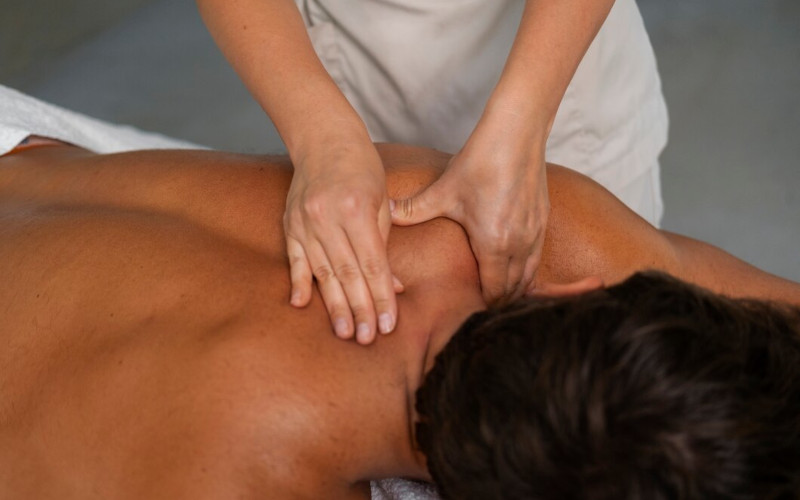 Licensed massage therapist at Uniq Massage in McKinney TX applying deep tissue pressure to relieve chronic muscle tension