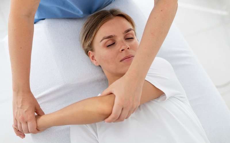 Licensed massage therapist at Uniq Massage in McKinney TX guiding a client through assisted Thai massage stretches